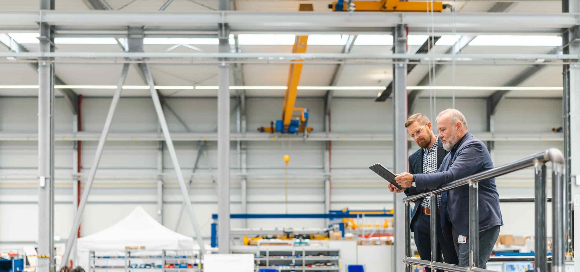 Geschäftsführer der Unterschütz Gruppe beide Unterschütz Geschäftsführer stehen auf einer Anlage mit Blick in die Werkhalle
